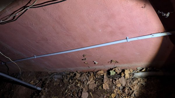 New HVAC power wire mounted to the foundation, wrapped in PVC pipe.