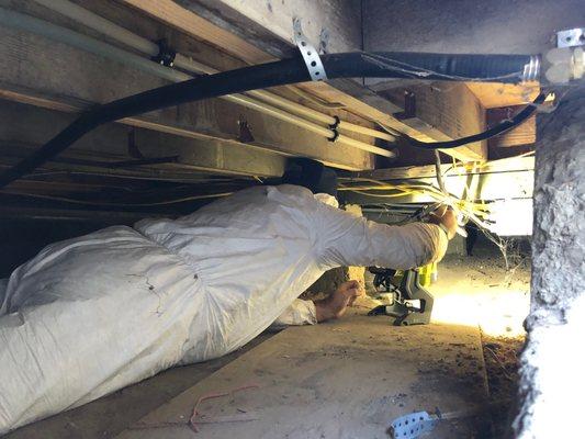 Inspecting Crawl Space underneath the foundation of a home.