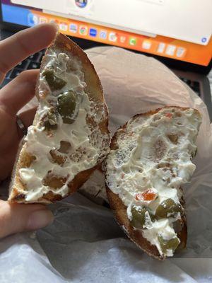 Everything Bagel with olive Cream Cheese Spread On Bagel **