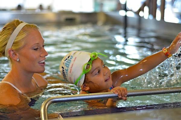 SwimLabs Instructor teaching freestyle on "the bar"