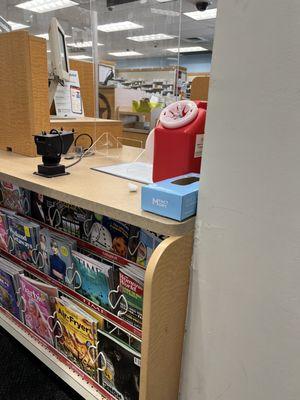 Look at the red container, dirty needles are popping out, lid is off. Dirty cotton ball on counter, yuck.