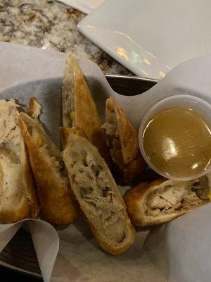 Chicken mashed potato and corn eggrolls with a side of gravy for dipping