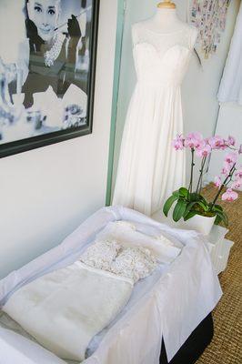 A preserved wedding dress with the muslin and lid removed. The acid free tissue paper has been opened to allow for viewing.