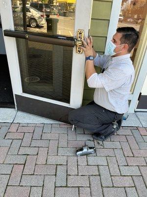 Locksmith reassembles latch after replacing broken parts.