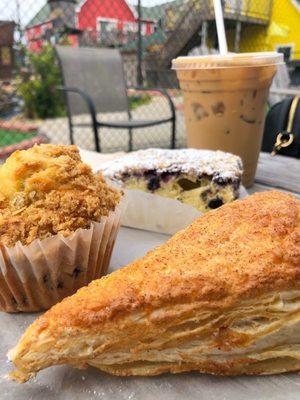 Blueberry muffin, apple turnover, coffee cake wit blueberries and a Vietnamese Iced coffee