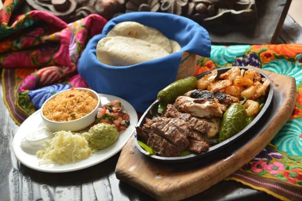 Fajitas for Two: Steak, Chicken Breast and Shrimp served with fresh guacamole, cheese and rice