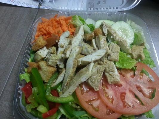 Sliced Jerk Chicken breast over a fresh salad.