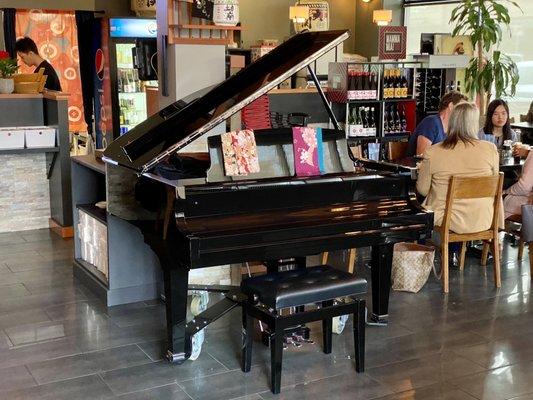 Piano in the center of the dining area at Sushi Mo restaurant