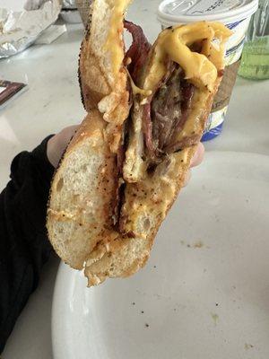 Turkey bacon, egg, & cheese with sautéed onions. Extra meat, eggs, and cheese on a hard roll.