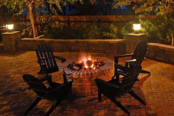 An outdoor fire pit by Weston Landscape & Design is an inviting, warm place for family and friends to gather.