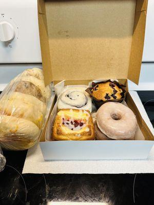 Three cheese, birdseed, and cinnamon raisin bagels. Homemade glazed donut, cheese & strawberry danish, cinnamon roll, and blueberry muffin.