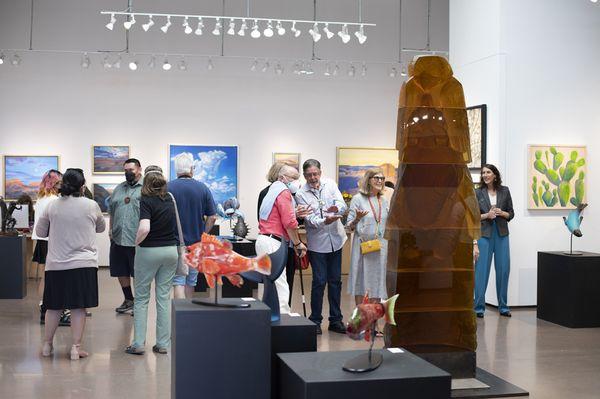 Clients admiring Preston Singletary's glass totem in the gallery during Native Art Week.