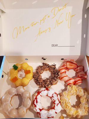 Half dozen: mango passionfruit, tiramisu, strawberry yogurt, glazed, strawberry funnel cake, and frosted flake