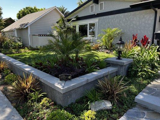 New stucco wall with concrete cap and tropical landscape