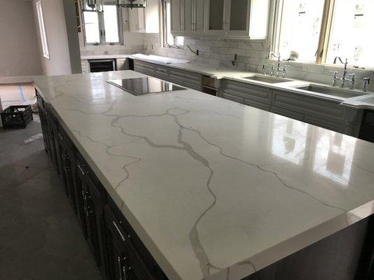 Leadstone Calacatta Quartz. Island is 155x51 with 45 degree miter edge. Seam in the middle is book matching and almost unnoticed.