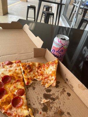 Two slices of pizza and a fizzy water