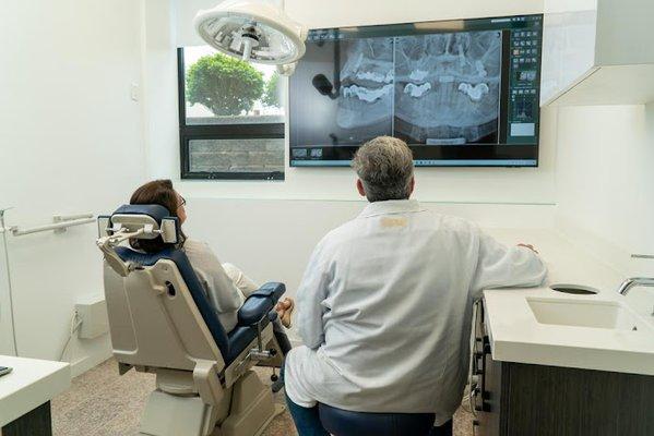 Dr. Ochs assisting a patient at one of Wisdom Oral Surgery's pristine patient rooms.