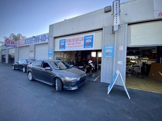 Shop storefront. Smog check in progress.