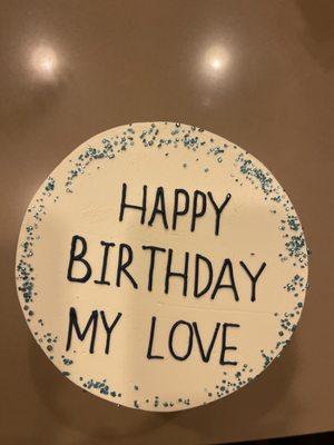 Birthday Cake with blue sprinkles on top.  The cake says "Happy Birthday My Love" in dark blue icing for the letters.