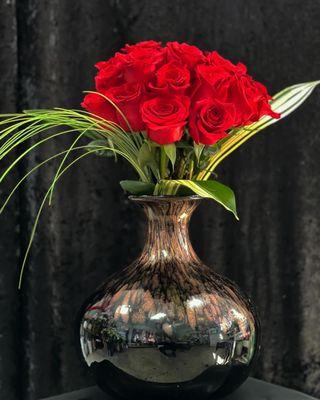 Desert Rose in a beautiful metallic vase red roses with exotic greens