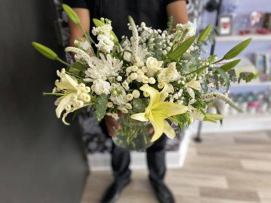 Estero Market Florist at Coconut Point Mall. A white sympathy bouquet featuring an assortment of garden inspired flowers.