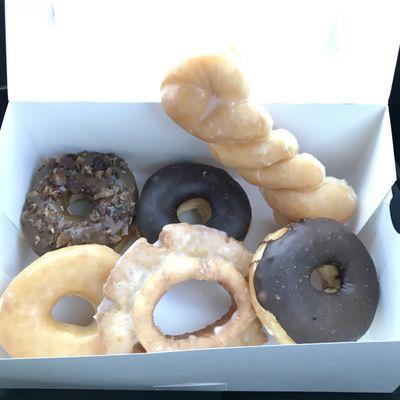 CW from top left: maple bacon, choc frosted, glazed twist, choc frosted, sour cream glazed, glazed!