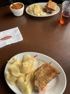 Half ham and cheese sandwich, chips, and tomato soup.