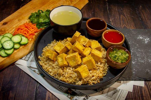 Fried tofu over a bed of ginger-garlic brown rice.  Dip it in your favorite sauce or drizzle all over your box!