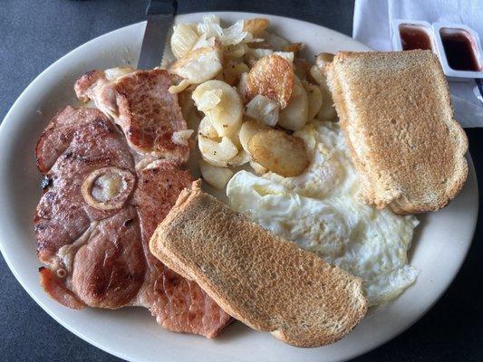 Ham steak, eggs, potatoes, wheat toast.