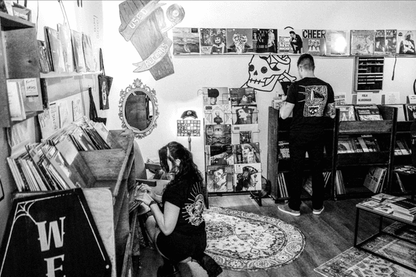 Digging through metal rock records. Traditional tattoo art on walls.