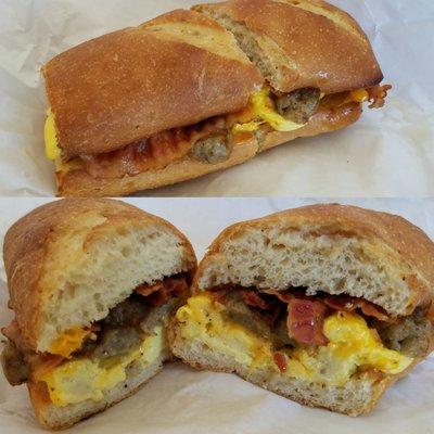 Fully loaded breakfast sandwich with egg, sausage, bacon, and cheddar on a toasted french roll!!