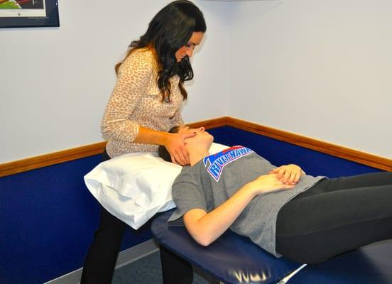 Therapist manipulating cervical spine for patient with headaches.