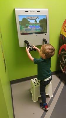 Arcade room with game systems and a car arcade game. My kid lives here during the short wait to get called back.