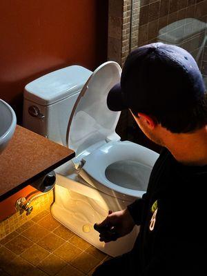 Our licensed plumber uses advanced leak detection tools to expertly diagnose and resolve toilet issues in a residential bathroom.