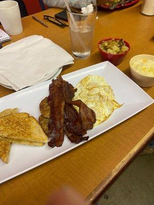 Big breakfast bacon sausage grits and potatoes