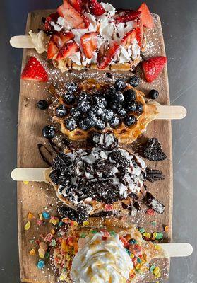 Four of our famous Waffle Pops.. top to bottom: Strawberries & Cream, Blueberry Honey, Oreo, and Fruity Pebbles