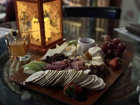 Charcuterie cheese and meat board with an old-fashion.