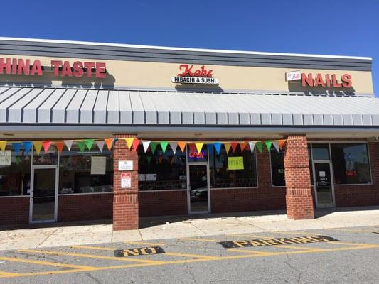 Exterior shot, with Grand Opening flags.