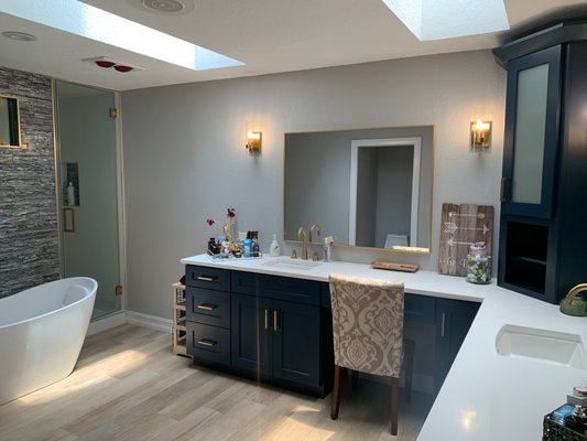 White quartz on royal blue shaker cabinets finished with gold pulls.