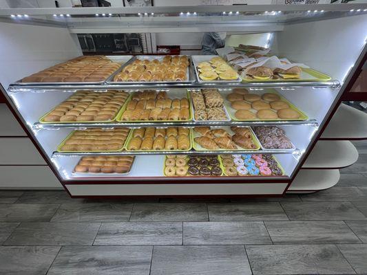 Variety of baked goods and donuts. There's another case that has all donuts.