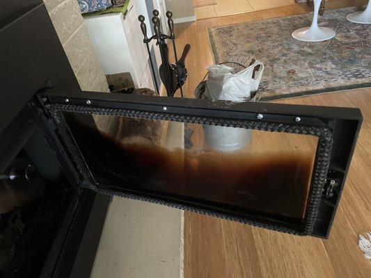 The inside of the glass door on the wood stove insert. It takes about an hour to remove the baked-on soot.