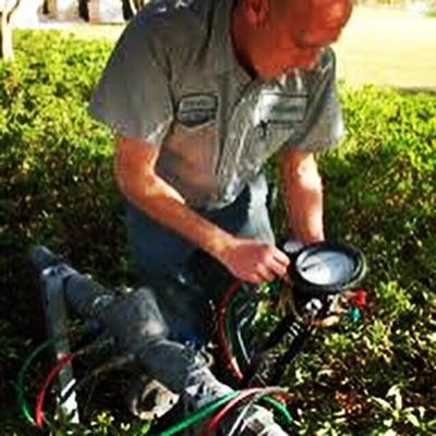 A technician testing a backflow prevention device