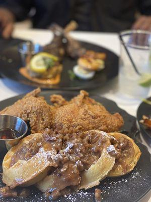 Specialty Chicken Waffles with butter pecan  and in background, lamb, Cajun Crab Cakes and deviled Dream Eggs w/ Blackened Shrimp