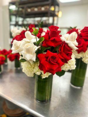 Red and white reflexed roses in a leaf lined vase