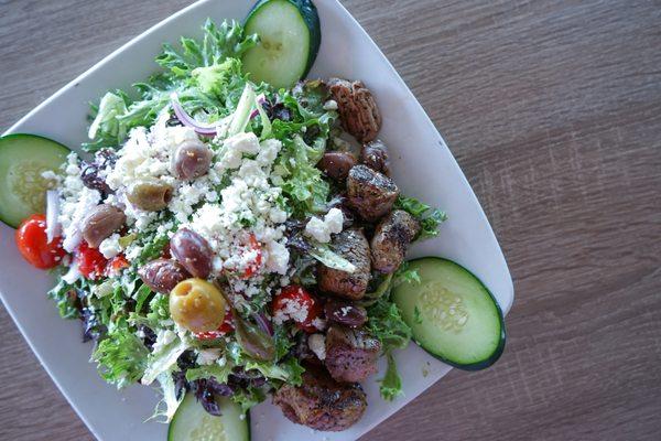 Beeside Salad - mixed greens, cucumbers, cherry tomatoes, red onions, mediterranean olives, feta, tzatziki dressing.
  
 Added lamb.