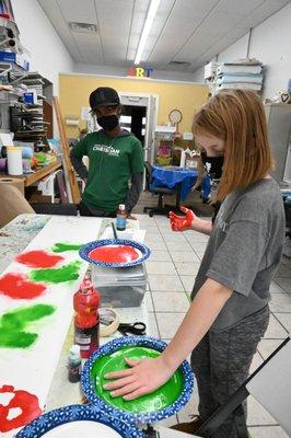 Open Studio students creating shelf liners for the ACWL-Nuveen front window holiday display.