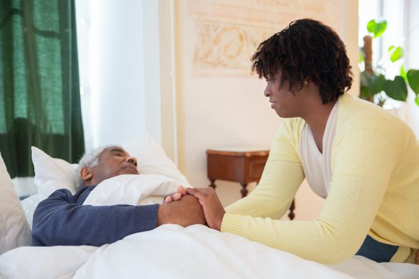 Image of one of our nursing staff tending to one of our patient's  bedside.