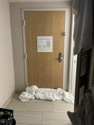 Door barricaded with wet towels.