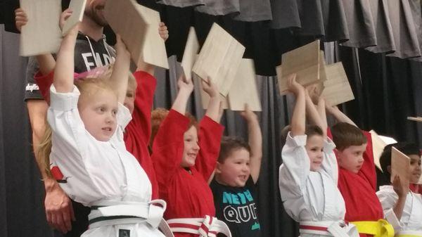 Dinos (ages 3 /12 -5) celebrate their new belts by breaking boards.