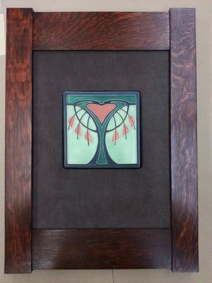 Art tile in a wrapped leather mat with a quarter-sawn oak frame.